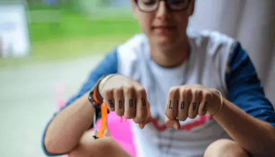 a young woman with the words boob love written on her knuckles