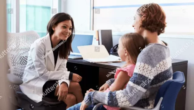 a female doctor speaks to a young woman and child