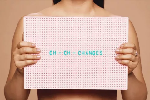 A person holding a sign saying 'Ch-ch-changes' | CoppaFeel! | Breast cancer info and advice
