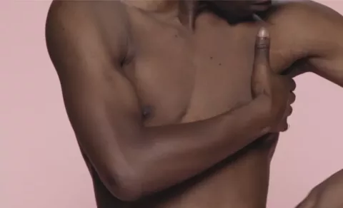 A black male checking his chest and under his armpits | CoppaFeel! | Breast cancer awareness
