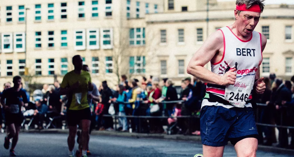 A man wearing a CoppaFeel! running vest whilst doing a running challenge