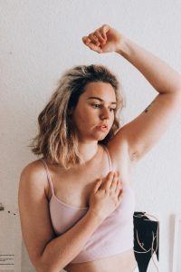 A picture of Ruby, a young woman with breast cancer showing how she checks her chest