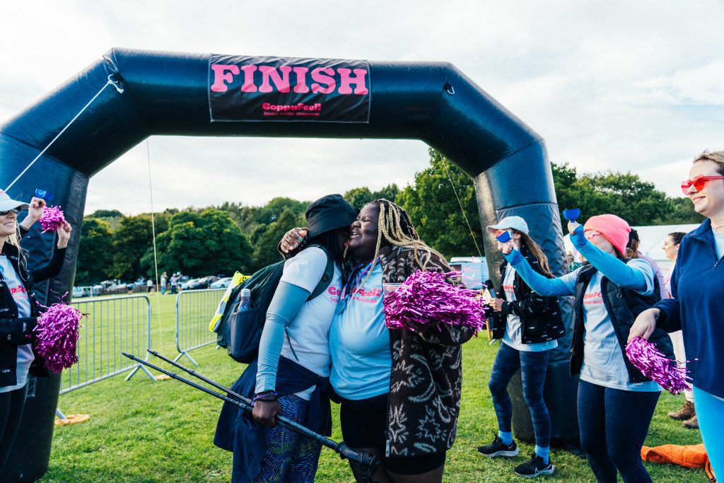 A picture of two black women at the finish line of CoppaTrek hugging each other